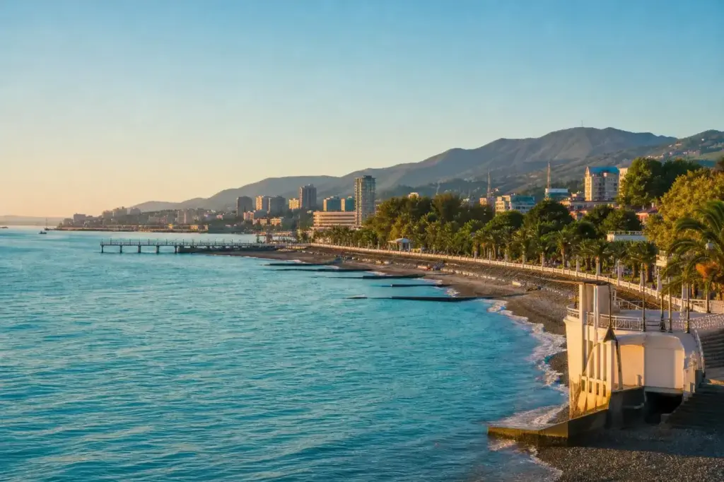 Sochi's Black Sea coastline with palm trees, turquoise water and distant Caucasus mountains